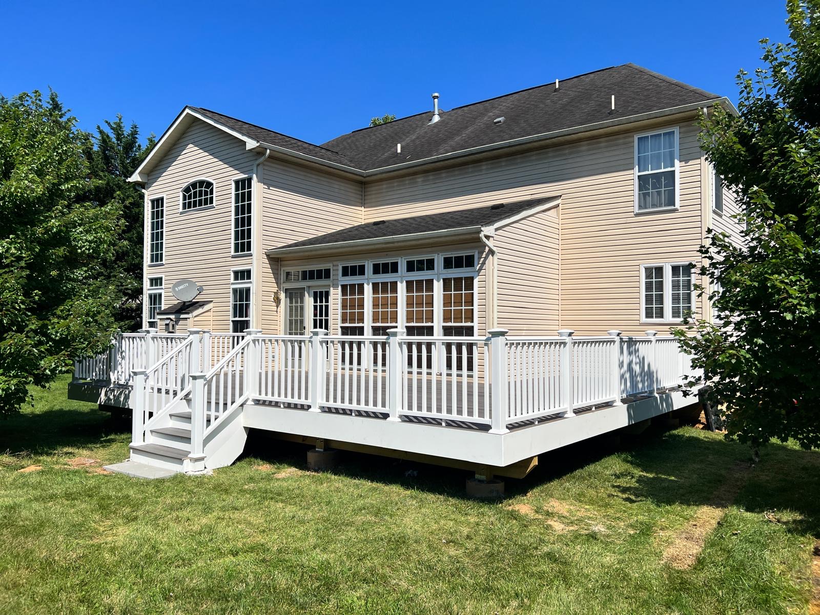 After — finished deck with white railings, composite flooring and new stairs