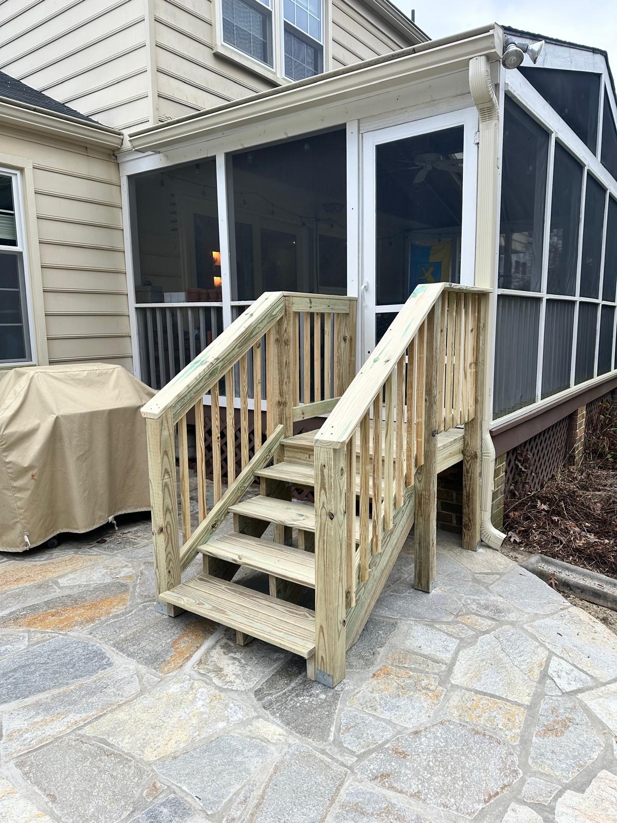 After — new wooden stairs with railing leading to the screened porch door