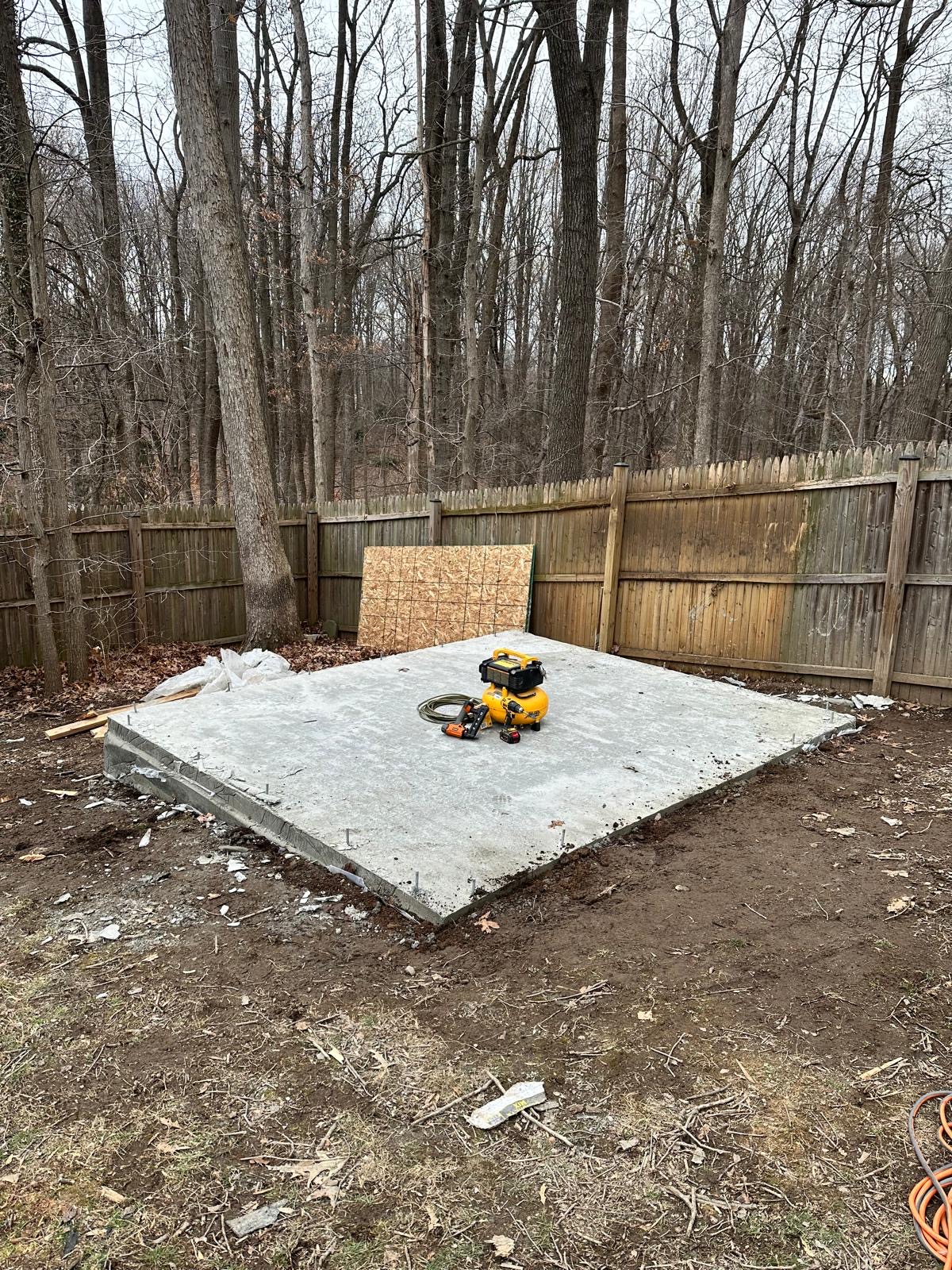 Before — concrete slab poured in the backyard, ready for the new shed