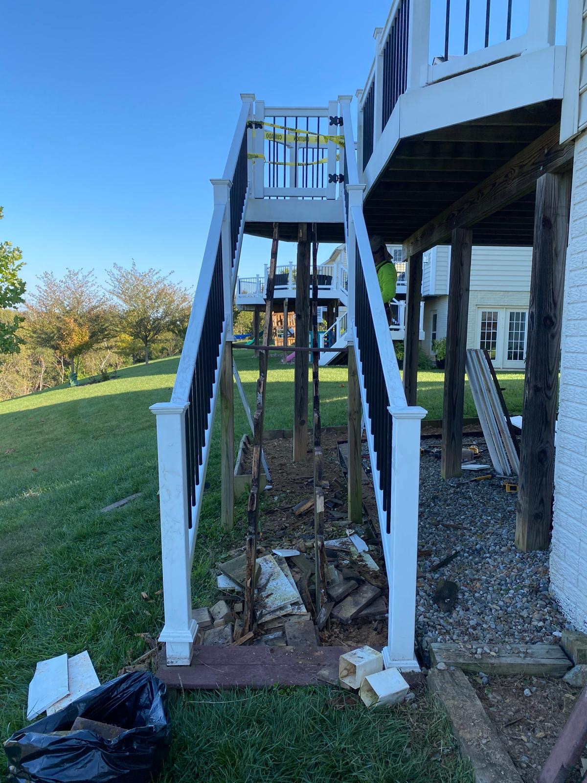 Before — old deck stairs demolished with debris under the new railings