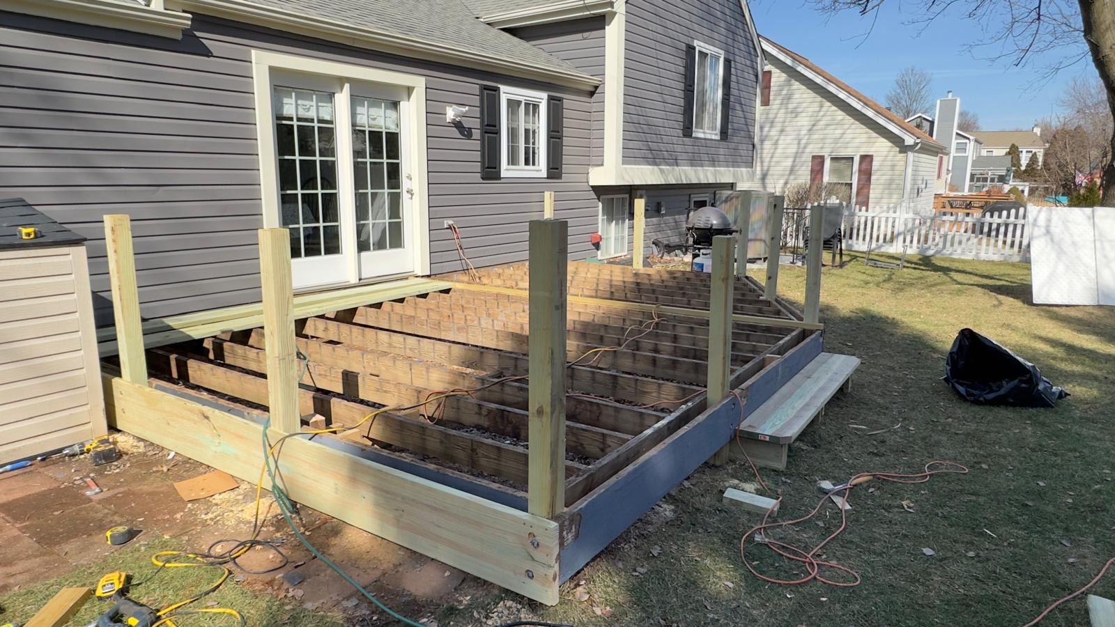 Before — deck stripped down to its framing with new support posts